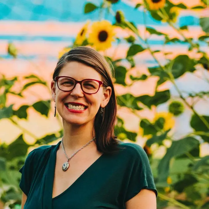 Rev. Celeste Kennel-Shank smiling among sunflowers